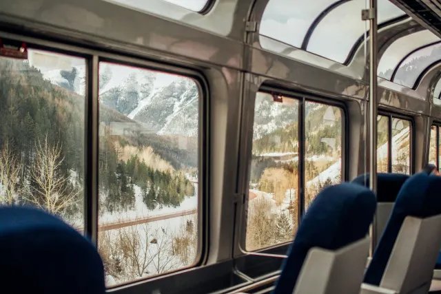 Snowy mountains seen through the panoramic windows of a scenic train