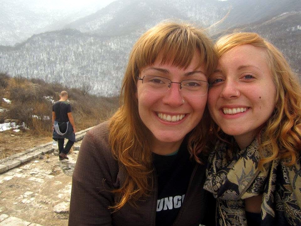 Emily and a friend smiling together on a stone path along the Great Wall